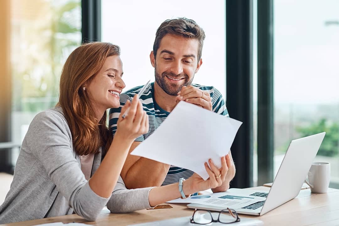 A married couple reviewing their budget and personal documents in preparation for a home loan.